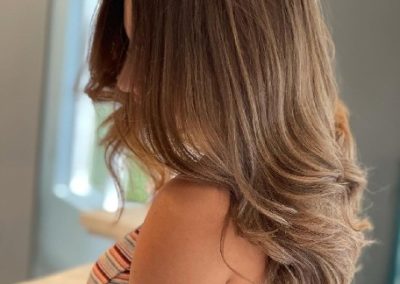 Brunette with wavy hair draped over her shoulder