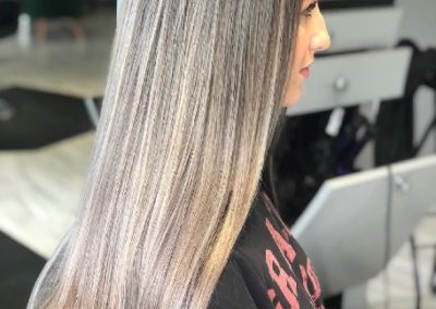 Woman with highlights and straightened hair shows her health hydrated hair